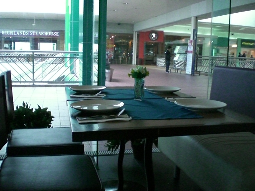 Here's daytime Azul view from inside facing the mall.  I wasn't able to adjust the camera settings so the colors don't show that well.  The chairs and tables are brown (and cream for the sofa) while the tablecloth is bluegreen with a skyblue glass vase.